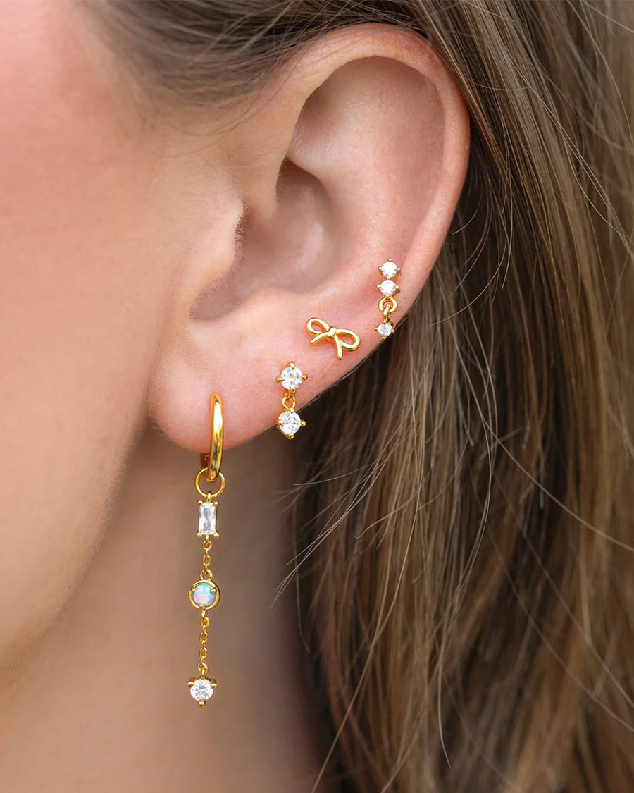 model wearing gold dangle earrings with crystal stud and drop