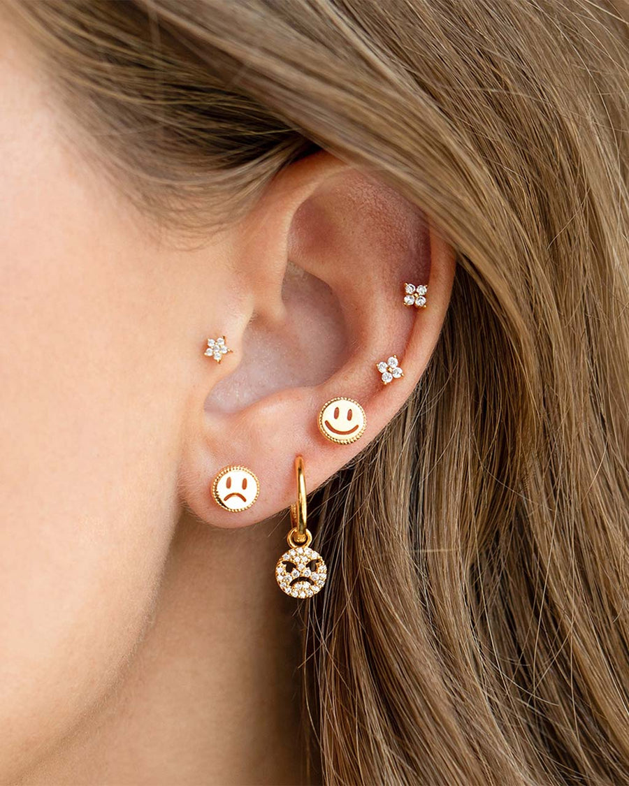 model wearing gold smiley and frown-y face stud earrings