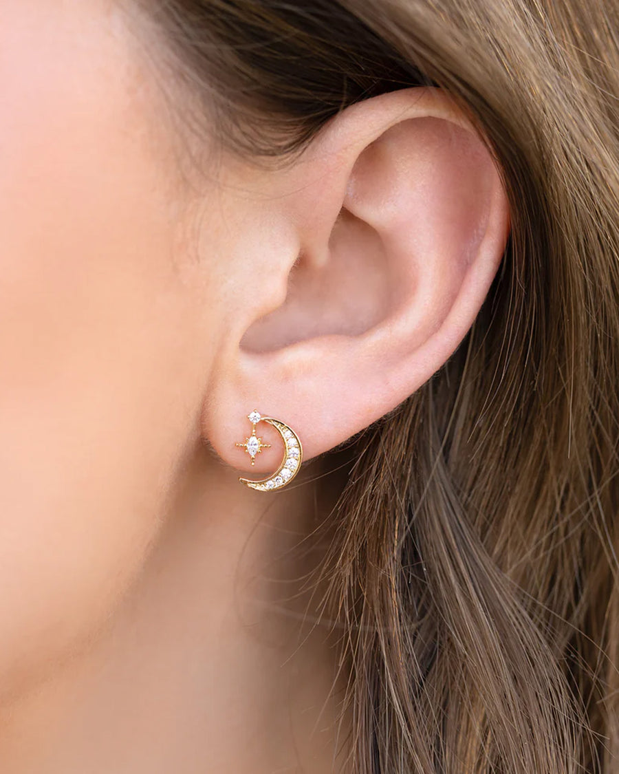 model wearing gold crystal earrings with moon and dangle star charm