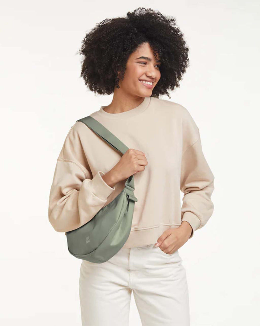model wearing sage green small got bag with subtle sheen