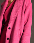 up close of model wearing long hot pink wool coat