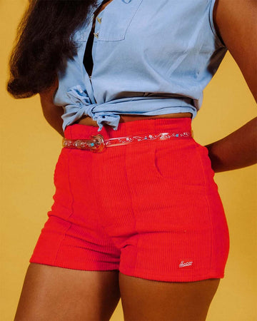 model wearing bright red corduroy shorts