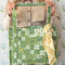 model holding green quilted tote bag with white floral print and teal interior