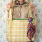 model holding yellow and white plaid tote bag with green print interior