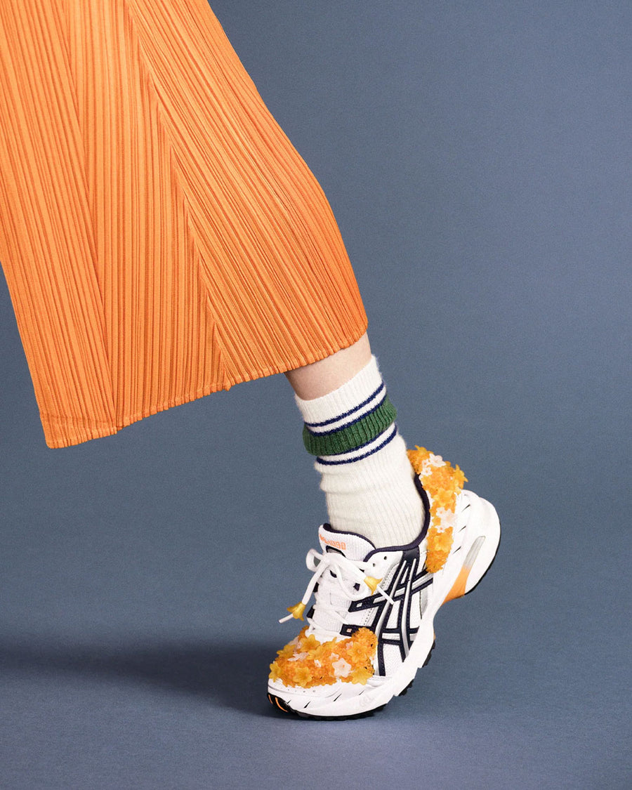 up close of model wearing white socks with green athletic stripes