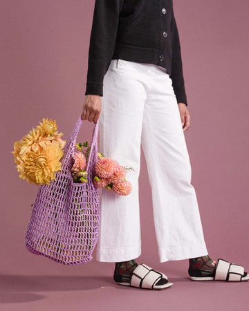 model holding wisteria paper crochet bag with flowers inside