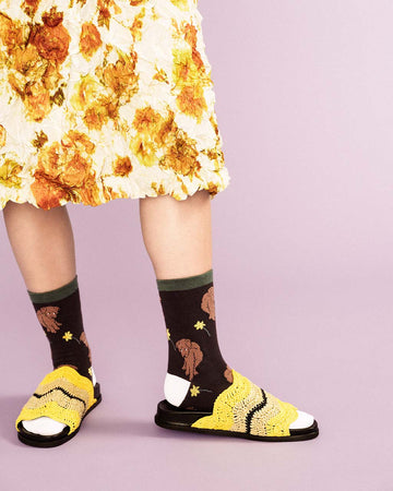 model wearing black socks with brown dog and daffodil print
