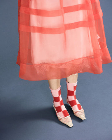 model wearing large pink and red checkered high socks