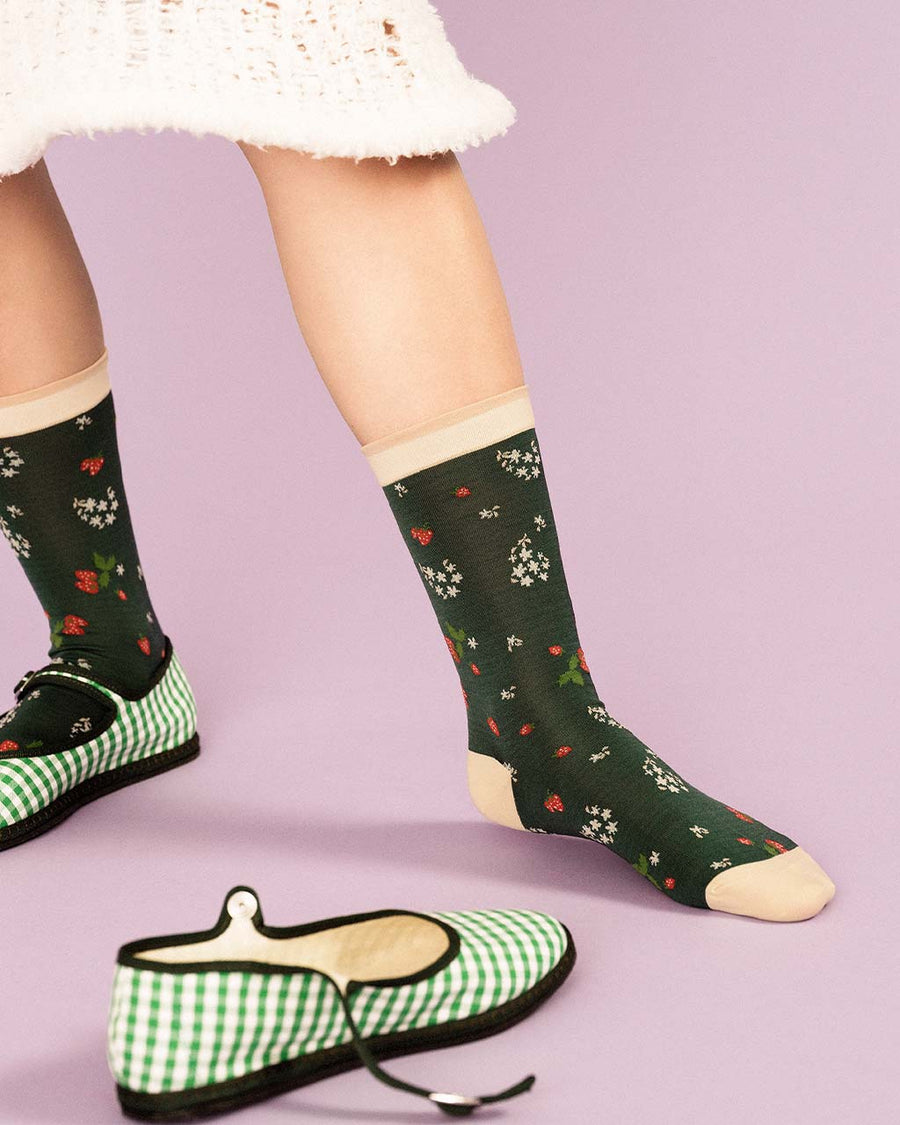 up close of model wearing green socks with delicate floral print and cream trim