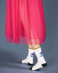 side view of model wearing white crew socks with blue flower design on the back