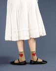 model wearing camel high socks with red heart print on both socks