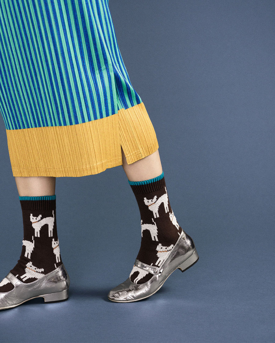 up close of model wearing mocha high socks with blue trim and white abstract cat print