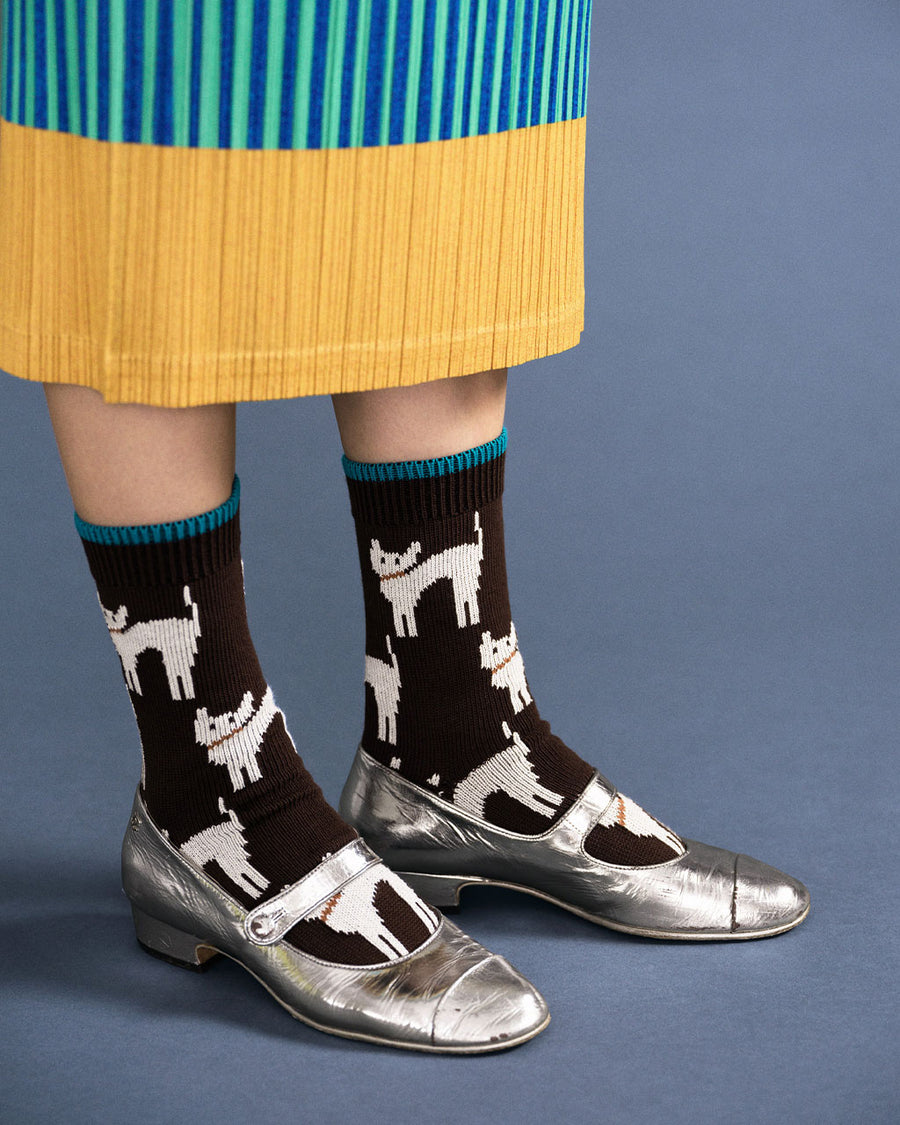 model wearing mocha high socks with blue trim and white abstract cat print
