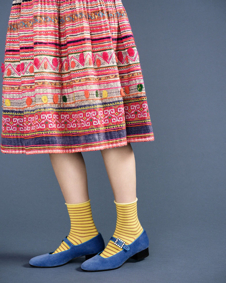 side view of model wearing yellow crew socks with brown thin stripes