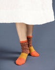 model wearing chunky socks with orange, yellow and brown color blocking