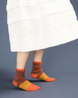 side view of model wearing chunky socks with orange, yellow and brown color blocking