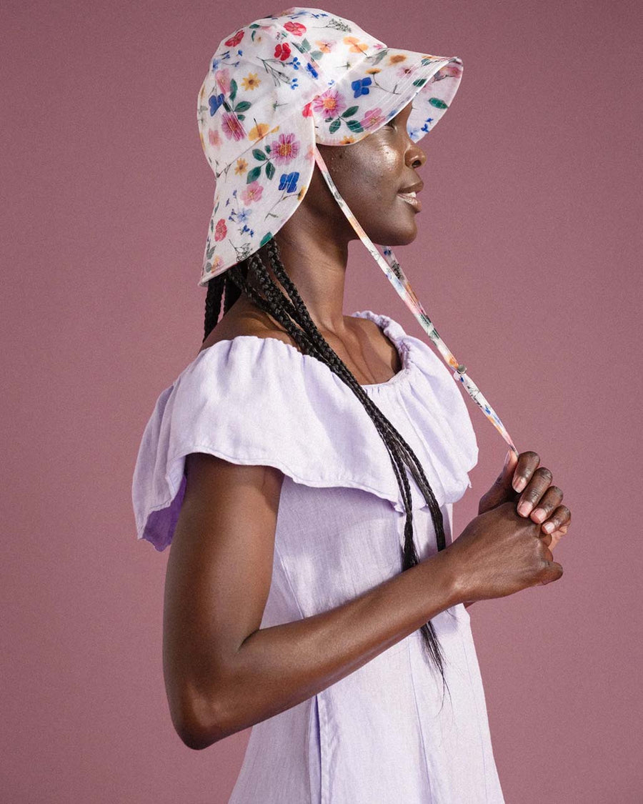 side view of model wearing white tulip bucket hat with colorful floral print