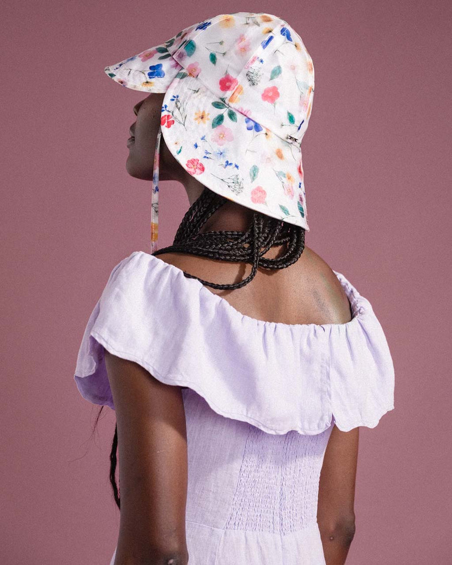 back view of model wearing white tulip bucket hat with colorful floral print