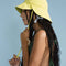side view of model wearing lemon tulip bucket hat with straps