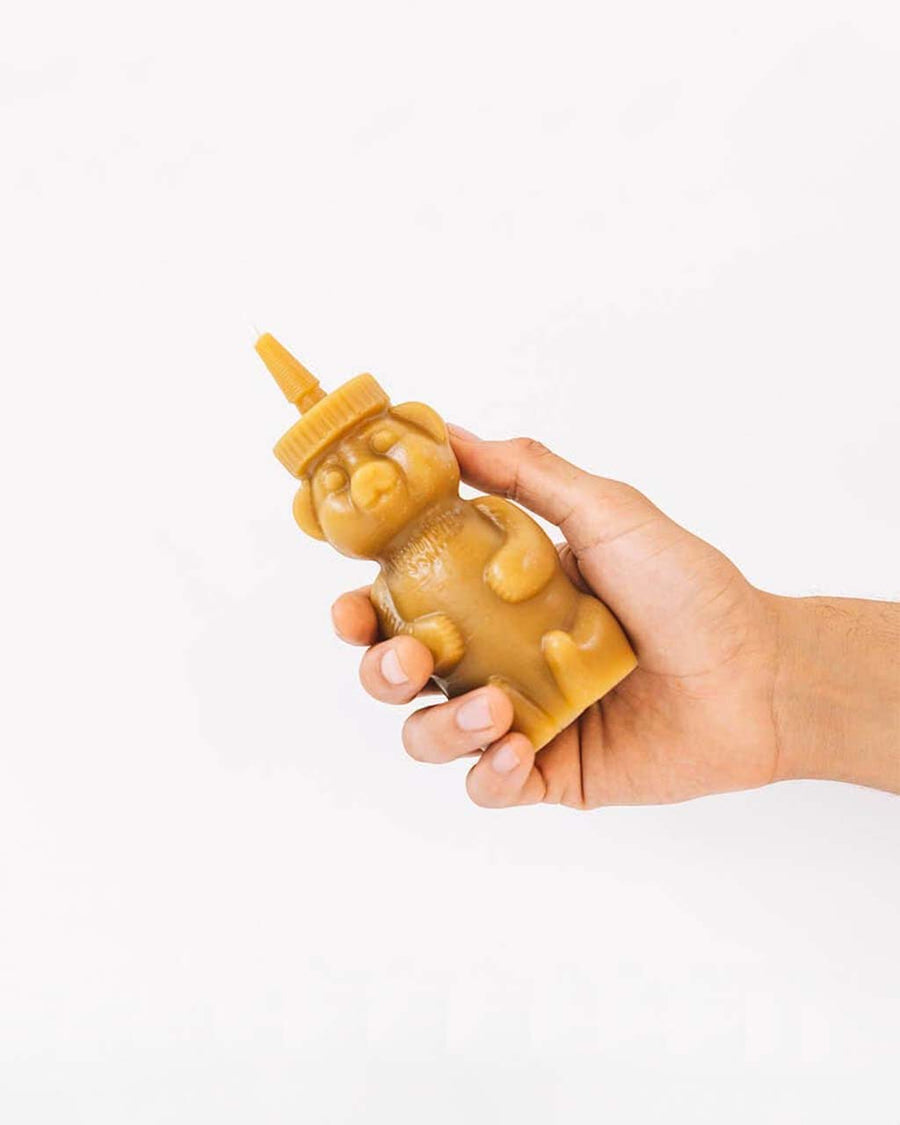 model holding honey bear shaped beeswax candle