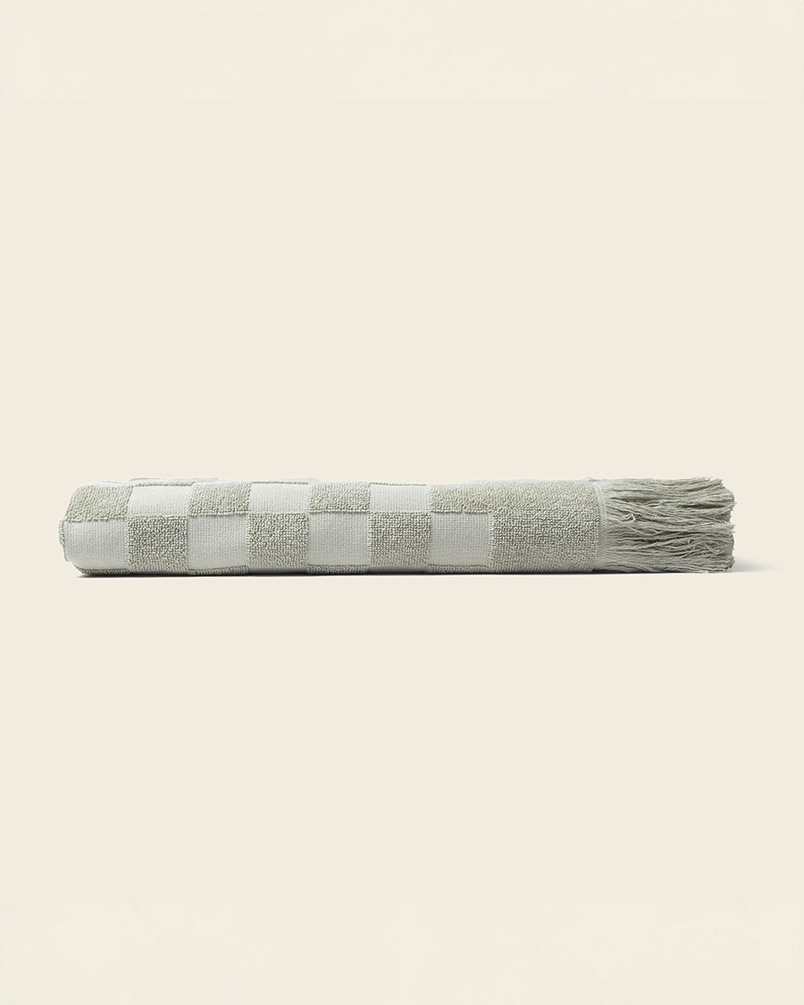 side view of folded sage checkered bath towel