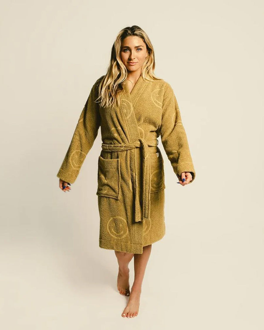 model wearing burnt mustard robe with embossed smiley design and front patch pockets