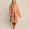 model wearing terra cotta robe with embossed smiley design and front patch pockets