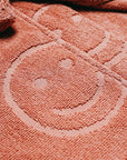 up close of terra cotta embossed smiley