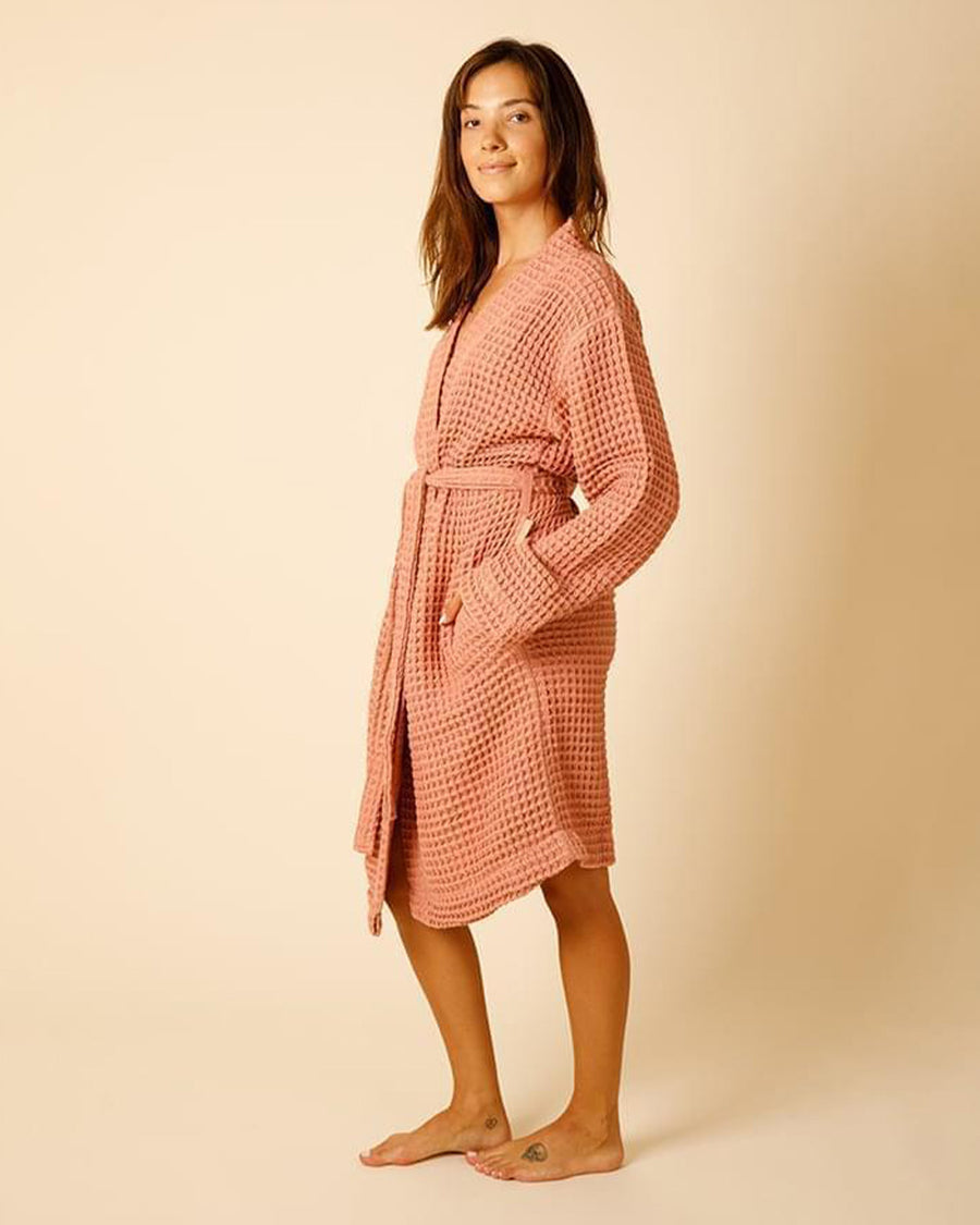 side view of model wearing terra cotta waffle bathrobe