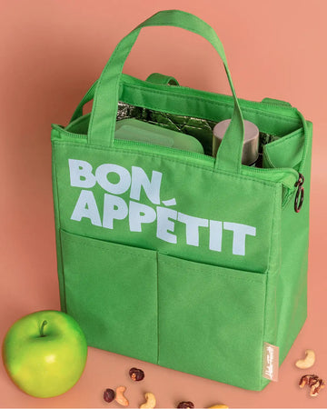kelly green lunch bag with light blue 'bon appetit' across the front on a peach background