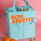 light blue lunch bag with orange 'bon appetit' across the front on a pink background