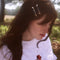 model wearing set of two dark green marbled setting clips with dainty white flower and gold accent