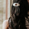 round pony barrette with tortoise quilt inspired six point star and black trim in models hair