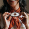 model wearing round pony barrette with tortoise quilt inspired six point star and black trim to hold their scarf
