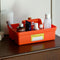 orange large storage caddy filled with beside items