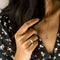 model wearing gold band ring with clear crystal baguette stone