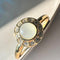 gold band ring with opal stone surrounded by crystal stone border