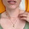 model wearing gold puffy star locket necklace