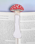 red and white mushroom shaped bookmark inside open book