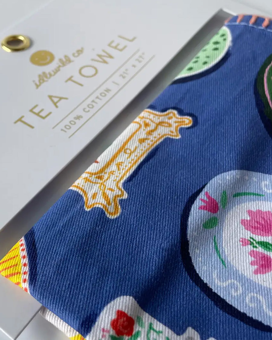 up close of cobalt cotton tea towel with colorful dinner plate print