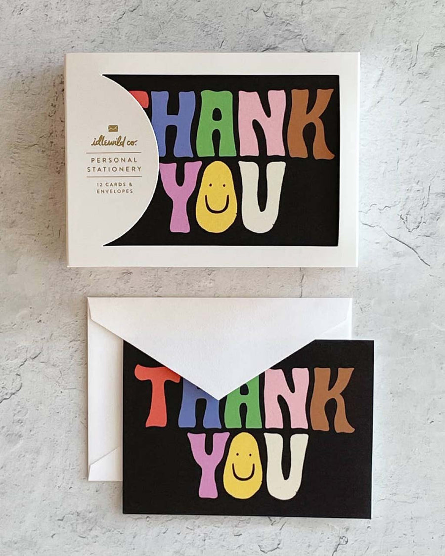 packaged thank you card set of 12 with black ground and wavy 'groovy' colorful 'thank you' with a smiley face