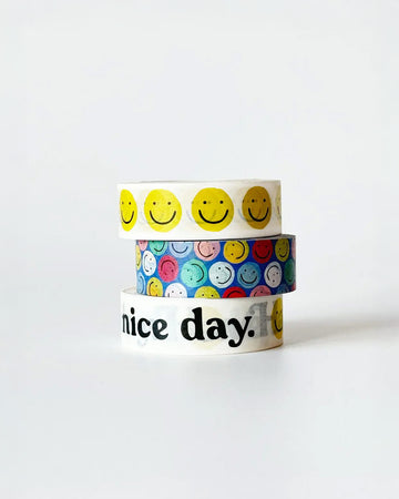 stacked set of three washi tape rolls: yellow smiley, blue with colorful smilies, and white with 'have a nice day' with a smiley