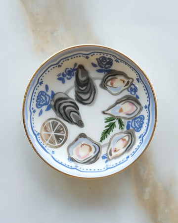 top view of white trinket tray with oyster print and gold accents