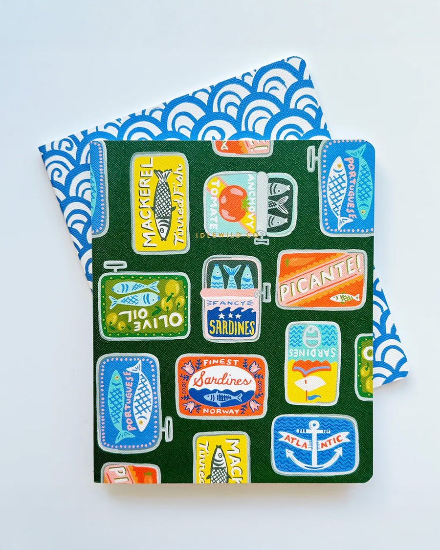 set of 2 notebooks with green with colorful tinned fish print and blue and white arch print