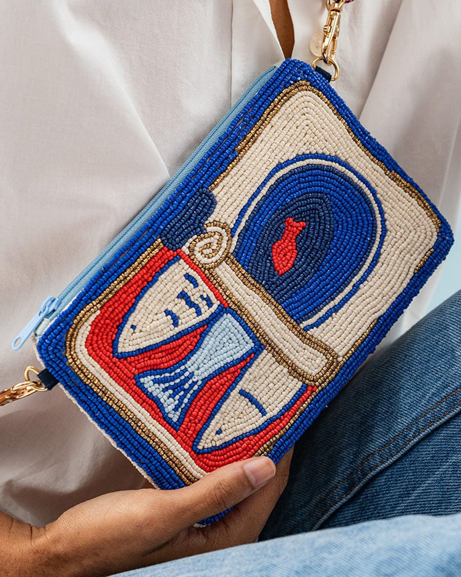 model wearing blue, orange and cream sardine beaded cutch with red removable strap
