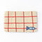 reverse cream and red grid beaded clutch with tiny sardine at the bottom