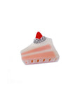 side view of cake hair clip with pink and white details and a strawberry on top