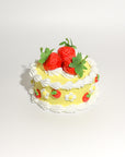 yellow fake cake kit with white 'frosting' and faux strawberries
