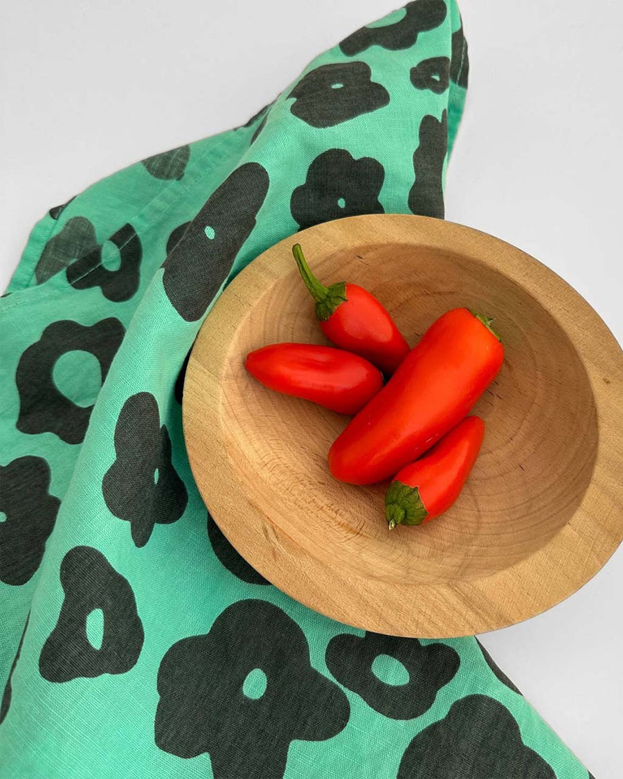 mint tea towel with black floral print with a bowl of peppers on it