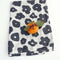 white tea towel with black floral print with orange on it